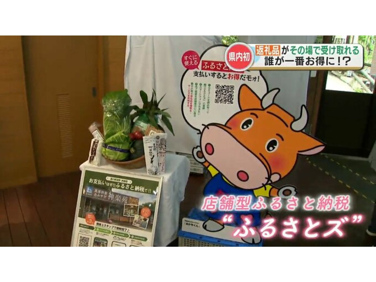 野菜のかごと牛のキャラクターの案内パネルを映し、「店舗型ふるさと納税“ふるさとズ”」とテロップが出たテレビ番組の画面