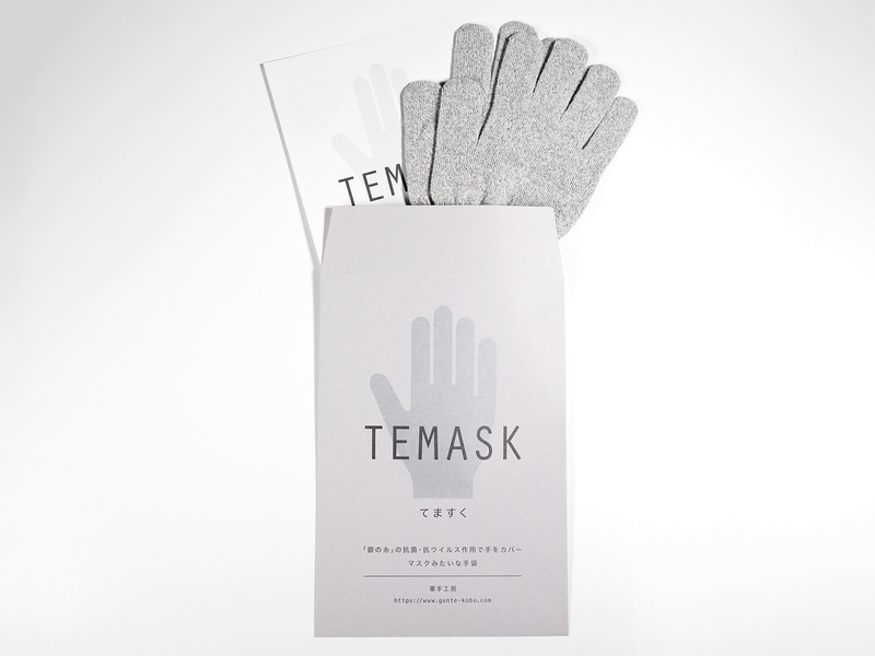 手のシルエットに「TEMASK てますく」と書かれた薄いグレーの袋から、グレーのニット手袋がのぞいているパッケージ